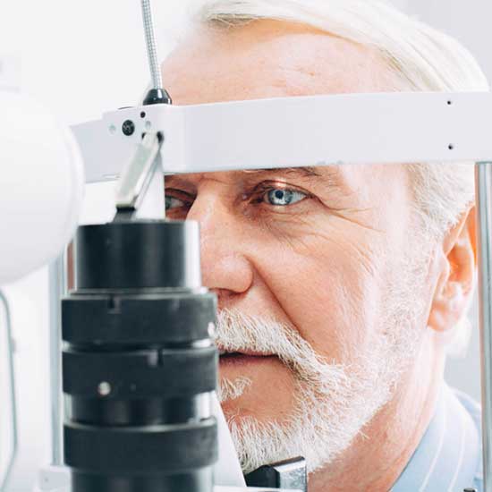 Frau mit Brille vor Sehtafel.