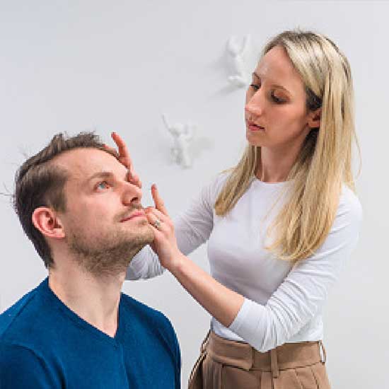 Frau beim Kontaktlinsen einsetzen.